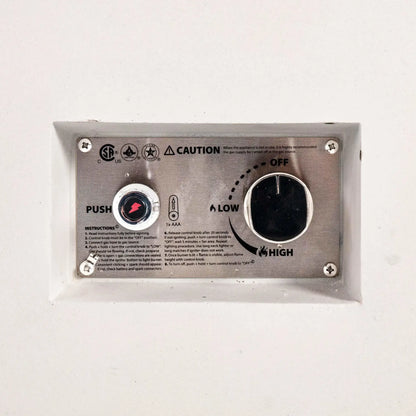 Detailed close-up of the Flame Havens Refuge Series 56 x 30 x 15 inch rectangle natural gas white GFRC concrete fire pit showing the recessed CSA-certified ignition control panel. The stainless steel faceplate features the push-button igniter, flame adjustment knob, operating instructions, and safety markings for reliable natural gas operation.