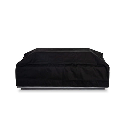 Black canvas fabric cover installed over the Flame Havens Refuge Series 56 x 30 x 15 inch rectangle straight natural gas GFRC concrete fire pit with the tempered glass wind guard remaining underneath. The weather-resistant cover is tailored to fit the fire pit's clean rectangular profile, providing year-round protection from rain, dust, UV exposure, and outdoor debris while maintaining a sleek, finished appearance.