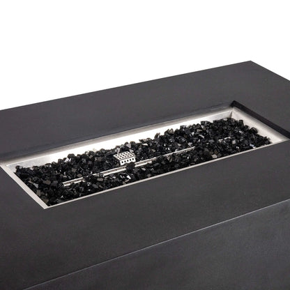 Angled close-up of the black Flame Havens Refuge Series 56 x 30 x 24-inch rectangular GFRC concrete propane gas fire pit, highlighting the recessed stainless steel burner pan, linear burner, protective ignition cage, and glossy black fire glass.