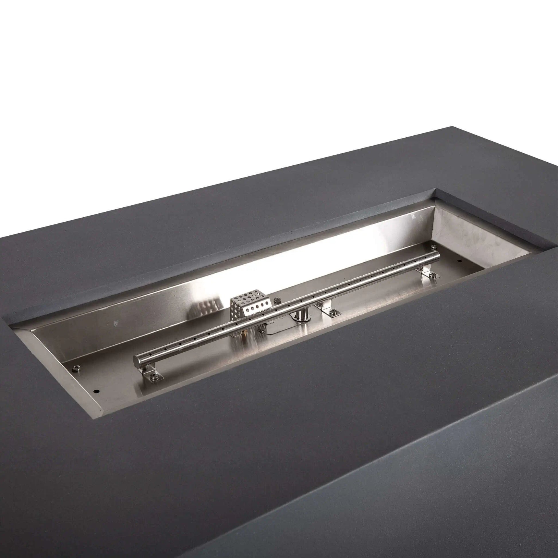 Angled close-up of the stainless steel burner assembly inside the Flame Havens Refuge Series 56 x 30 x 24-inch gray rectangular propane fire pit. The empty burner pan reveals the linear burner tube, evenly spaced flame ports, mounting brackets and perforated CSA ignition component.