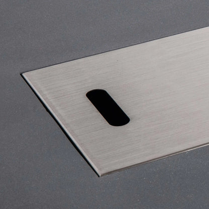 Close-up of the brushed stainless steel burner cover fitted into the Flame Havens Refuge Series 56 x 30 x 24-inch rectangular gray propane fire pit. The image highlights the cover’s smooth metal grain, clean flush-mounted edges and rounded rectangular handle opening against the textured GFRC concrete surface.