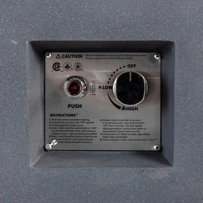 Close-up of the recessed CSA ignition controls on the Flame Havens Refuge Series 56 x 30 x 24-inch gray rectangular propane fire pit. The stainless steel panel includes a push-button spark igniter, AAA battery indicator, large flame adjustment knob marked Off, Low and High, certification symbols, caution notice and lighting instructions.
