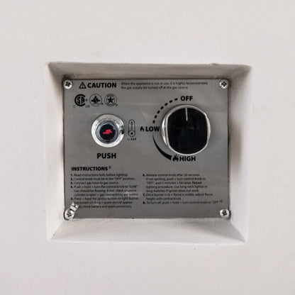 Close-up of the recessed CSA ignition controls on a white Flame Havens Refuge Series 56 x 30 x 24-inch rectangular propane gas fire pit, showing the push-button spark igniter, AAA battery indicator, OFF-to-LOW-to-HIGH flame control knob, safety certifications, caution notice, and lighting instructions.