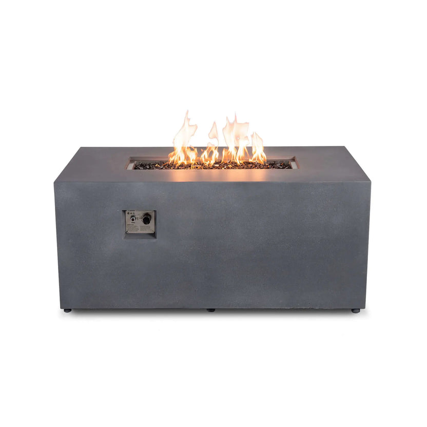 Straight front product view of the Flame Havens Refuge Series 56 x 30 x 24-inch gray GFRC rectangular propane fire pit with the fire on. Yellow-orange flames burn above tempered black fire glass in the recessed stainless steel burner, and the front-mounted ignition button and flame adjustment control are clearly visible.