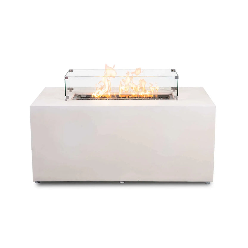 Straight front view of the Flame Havens Refuge Series 56 x 30 x 24-inch rectangular propane gas fire pit in white GFRC concrete, shown burning over tempered black fire glass with a clear tempered glass wind guard, polished metal corner brackets, raised feet, a wide tabletop ledge, and discreet adjustable feet.