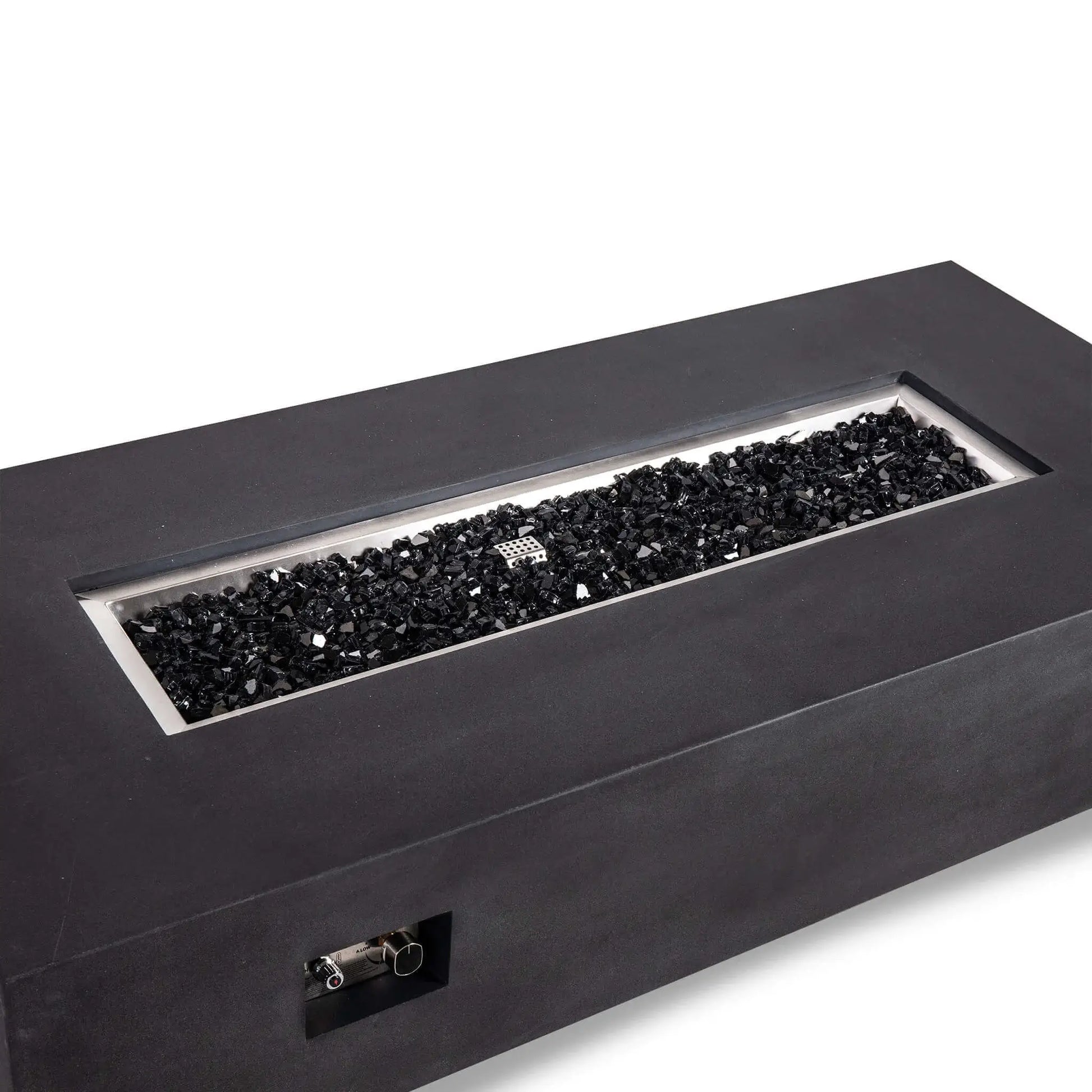 Angled close view of the Flame Havens Refuge Series 68 x 30 x 15-inch rectangular natural gas fire pit in black GFRC concrete. The recessed stainless steel burner pan is filled with reflective black fire glass, while the built-in ignition and flame control panel is visible on the front.