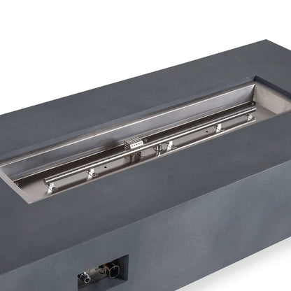 Close angled view of the Flame Havens Refuge Series 68 x 30 x 15-inch natural gray GFRC fire pit with the fire media removed. The image highlights the stainless steel burner pan, linear natural gas burner, ignition cage, mounting hardware, and recessed front control panel.