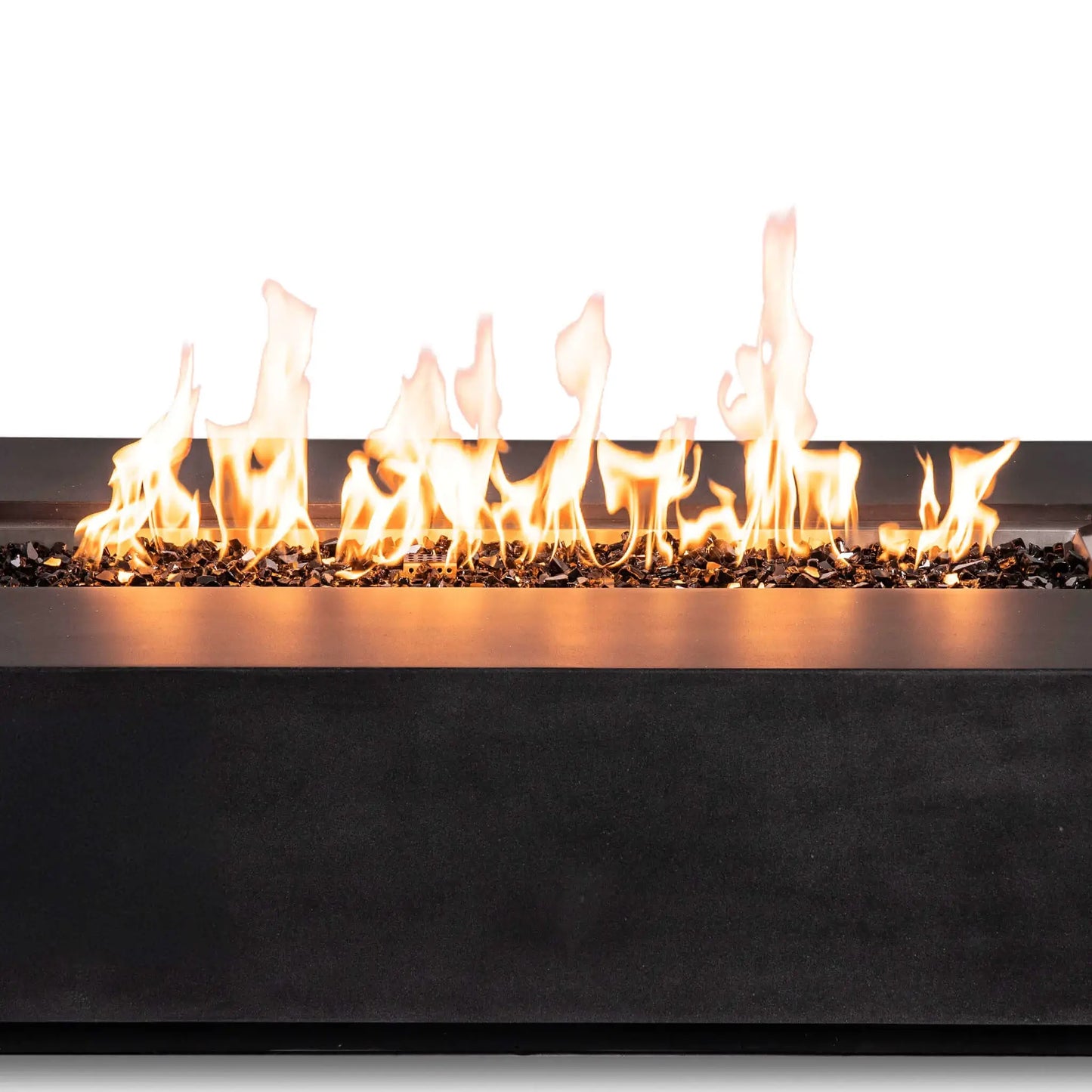 Close-up of active natural gas flames stretching across reflective tempered black fire glass in the Flame Havens Refuge Series 68 x 30 x 15-inch rectangular fire pit. The image highlights the varied flame heights, stainless steel burner-pan edge, dark GFRC concrete finish, and concealed-control design.