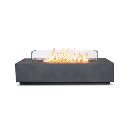 Straight front product view of the Flame Havens Refuge Series 68 x 30 x 15-inch rectangular natural gas fire pit in gray GFRC concrete. A line of bright flames rises over tempered black fire glass inside a clear tempered glass wind guard, displayed against a clean white background.