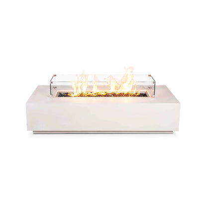 Flame Havens Refuge Series 68 x 30 x 15-inch white GFRC rectangular natural gas fire pit shown burning against a white background. A tempered glass wind guard with stainless steel corner hardware surrounds the bright flames rising from reflective tempered black fire glass.
