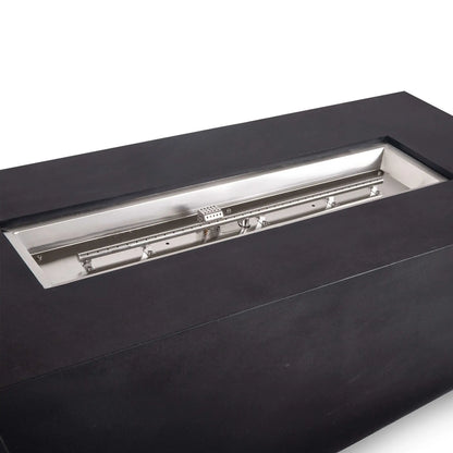 Angled close-up of the Flame Havens Refuge Series black GFRC concrete propane fire pit, showing the full stainless steel burner pan, linear burner tube, mounting brackets, gas fittings, and protective ignition cage within the 68 x 30 x 24-inch rectangular design.