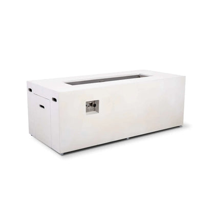 Angled product view of the Flame Havens Refuge Series 68 x 30 x 24-inch rectangular propane gas fire pit in white GFRC concrete. The image shows its recessed stainless steel burner pan, built-in tank access door, ventilation openings, adjustable feet, and recessed CSA ignition control panel.