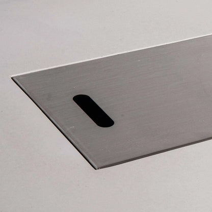 Close-up of the brushed stainless steel burner cover for the Flame Havens Refuge Series 68 x 30 x 24-inch rectangular propane fire pit. The image highlights the smooth metal finish, clean beveled edge, and elongated hand slot used to lift the cover from the white GFRC concrete fire pit.