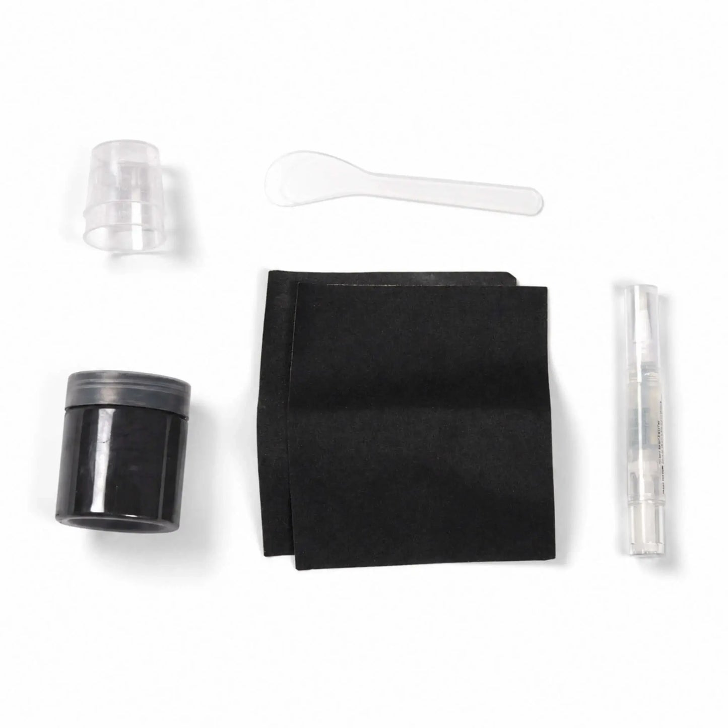 Contents of the Flame Havens Refuge Series Black concrete surface care kit arranged on a white background. The color-matched repair set includes a jar of black material, two black application pads, small clear mixing cups, a plastic mixing spoon, and a clear pen-style applicator.