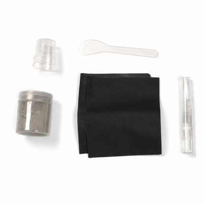Contents of the Flame Havens Refuge Series Gray concrete surface care kit displayed on a white background. The color-matched repair set includes a jar of gray material, two black application pads, small clear mixing cups, a plastic mixing spoon, and a clear pen-style applicator.