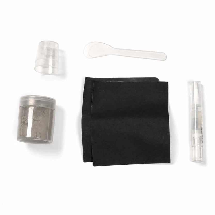 Contents of the Flame Havens Refuge Series Gray concrete surface care kit displayed on a white background. The color-matched repair set includes a jar of gray material, two black application pads, small clear mixing cups, a plastic mixing spoon, and a clear pen-style applicator.