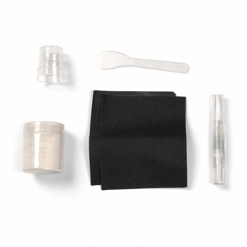 Contents of the Flame Havens Refuge Series White concrete surface care kit arranged on a white background. The color-matched repair set includes a jar of white material, two black application pads, small clear mixing cups, a plastic mixing spoon, and a clear pen-style applicator.