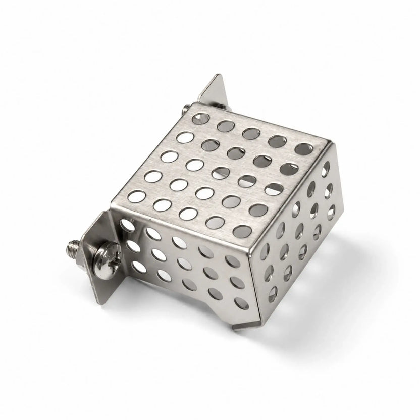 Angled product view of the Flame Havens Refuge Series ignition shield on a white background. The stainless steel protective enclosure has perforated top, front, and side panels, folded edges, mounting brackets, and visible screw hardware designed to secure the shield around the fire pit’s ignition components.