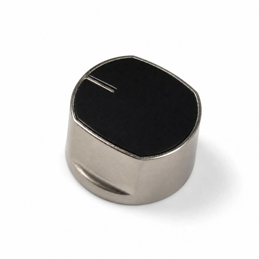 Angled view of the Flame Havens Refuge Series fire pit control knob on a white background. The replacement knob has a smooth black top with a raised position indicator, a brushed silver metal body, rounded edges, and a shallow side grip for easier turning.