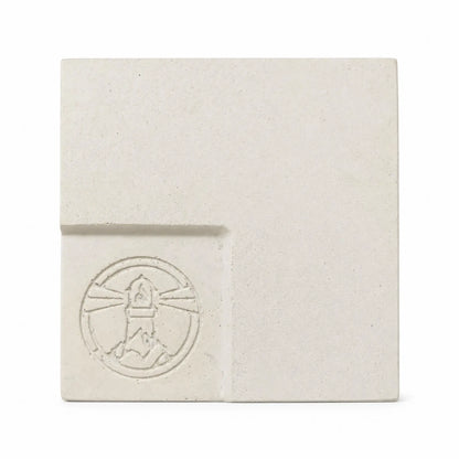 Flame Havens Refuge and Serenity Series GFRC glass fiber reinforced concrete sample in Ivory White. The square finish swatch features a warm off-white tone, natural speckling, subtle surface variation, rounded edges, and a recessed lower-left panel with an embossed Flame Havens emblem.