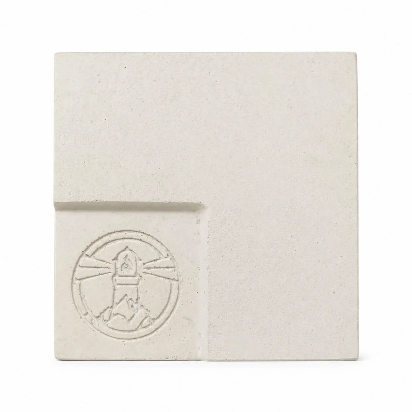 Flame Havens Refuge and Serenity Series GFRC glass fiber reinforced concrete sample in Ivory White. The square finish swatch features a warm off-white tone, natural speckling, subtle surface variation, rounded edges, and a recessed lower-left panel with an embossed Flame Havens emblem.