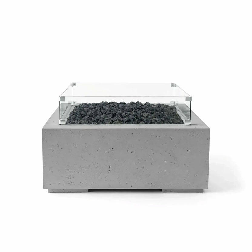 HPC Fire Hearth Products Controls Dekko GFRC Concrete Alea 32 x 32 Fire Pit in Charcoal finish featuring black lava rock fire media enclosed by a tempered glass wind guard. The square GFRC concrete fire pit displays a bold contemporary aesthetic with textured charcoal concrete and a recessed burner area, shown in a clean white-background product photograph.