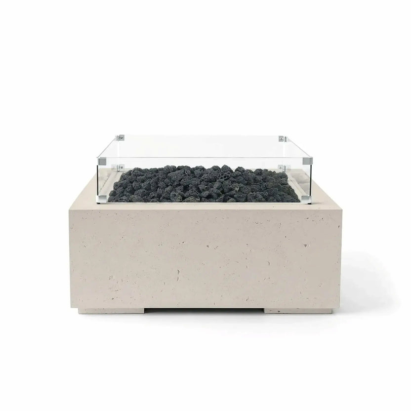 HPC Fire Hearth Products Controls Dekko GFRC Concrete Alea 32 x 32 Fire Pit in Clay finish with black lava rock media and a tempered glass wind guard. This square GFRC concrete fire pit features a light beige textured finish, contemporary design, and recessed burner area, shown in a centered product image on a white background for e-commerce display.