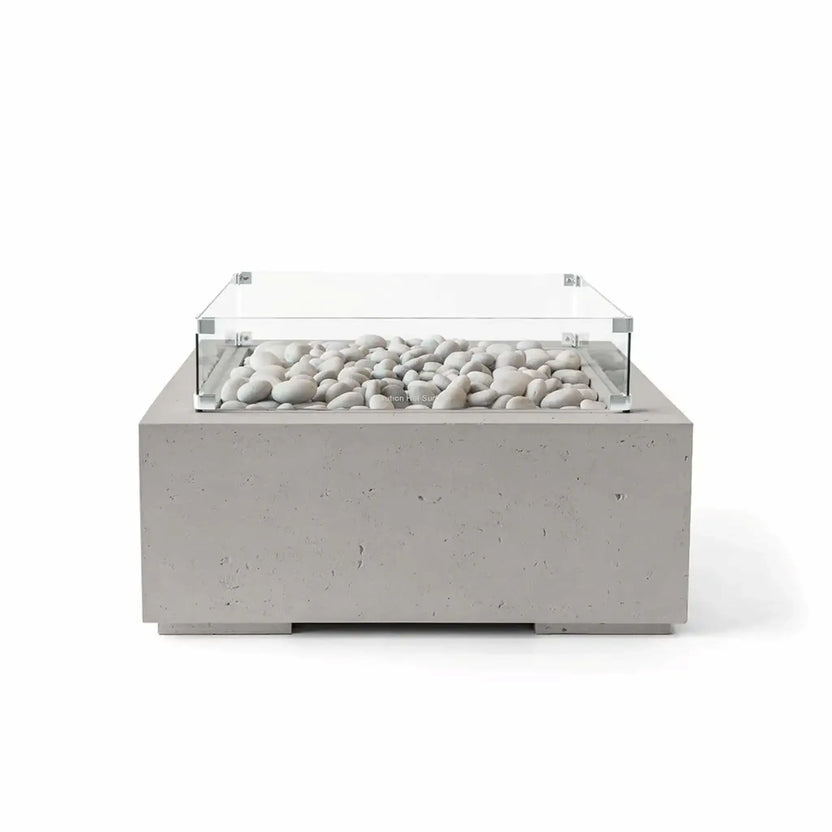 HPC Fire Hearth Products Controls Dekko GFRC Concrete Alea 32 x 32 Fire Pit in Sandstone finish featuring ivory fire stones and a clear tempered glass wind guard. The square GFRC concrete fire pit displays a warm sandstone-colored exterior, clean geometric profile, and decorative stone media, making it a stylish centerpiece for modern patios and outdoor gathering areas.