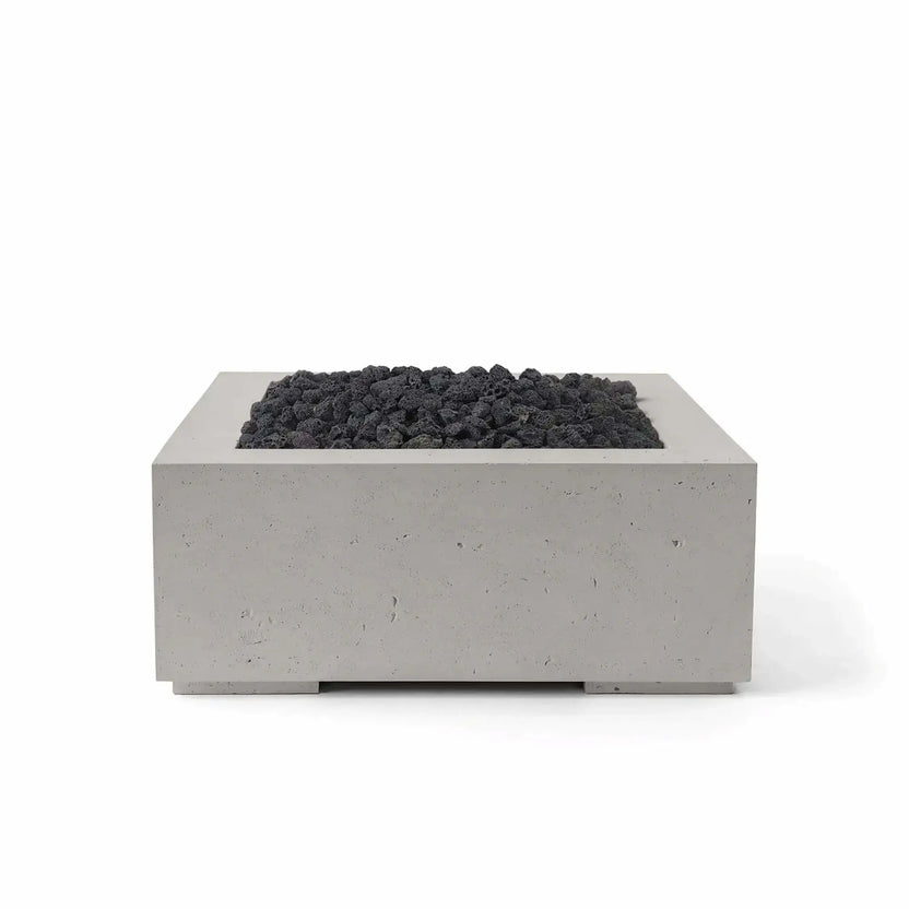 HPC Fire Hearth Products Controls Dekko GFRC Concrete Alea 32 x 32 Fire Pit featuring a Sandstone finish and black lava rock media. The square GFRC concrete fire pit showcases contemporary design, a recessed burner section, and rugged volcanic rock that creates striking contrast against the warm sandstone tone. Ideal for outdoor entertaining areas, patios, and landscape projects, the Alea fire pit offers a timeless modern appearance.