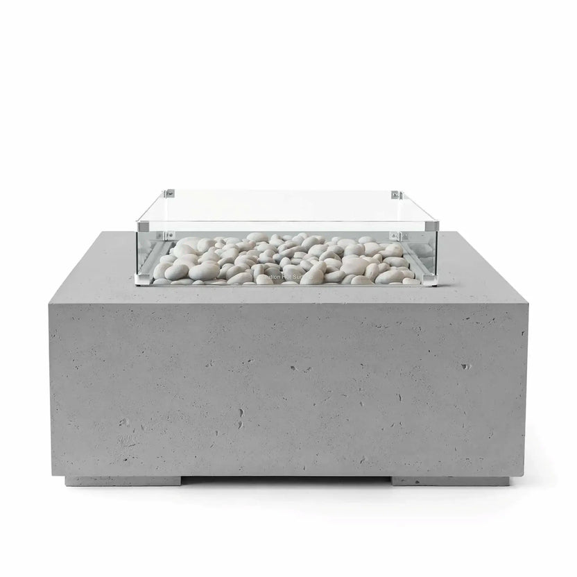 HPC Fire Hearth Products Controls Dekko GFRC Concrete Alea 40 x 40 Fire Pit in Charcoal finish featuring smooth ivory fire stones beneath a clear tempered glass wind guard. The square outdoor fire table showcases a darker concrete body with subtle texture, creating a striking contrast against the white stone media. Professional studio image highlighting the modern architectural design.
