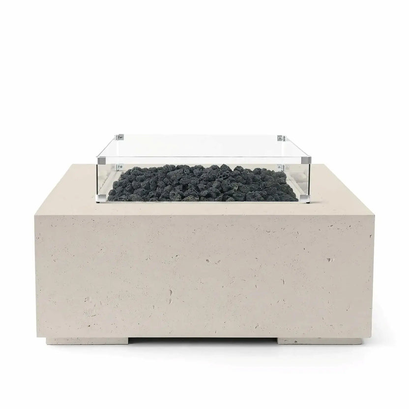 HPC Fire Hearth Products Controls Dekko GFRC Concrete Alea 40 x 40 Fire Pit finished in Clay with natural black lava rock media. The square concrete fire pit features a clear tempered glass wind guard around the burner area, creating a refined contrast between the light beige GFRC concrete base and rugged volcanic rock. Studio product image designed for outdoor fire feature presentation.