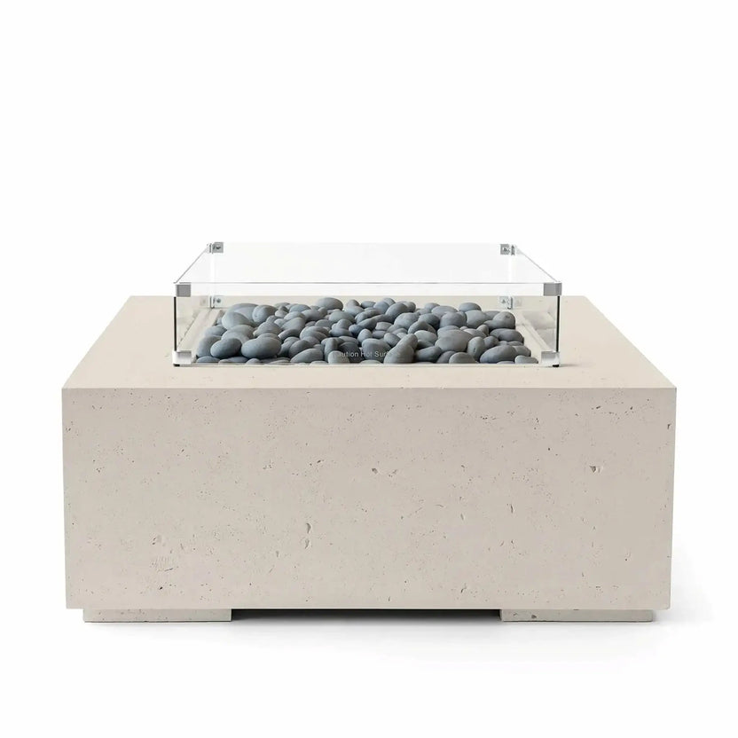 HPC Fire Hearth Products Controls Dekko GFRC Concrete Alea 40 x 40 Fire Pit in Clay finish with smooth slate stone fire media beneath a tempered glass wind guard. The durable GFRC concrete construction features a warm neutral color and minimalist square shape, making it ideal for modern patios and outdoor gathering spaces. Professional product image on a white background.