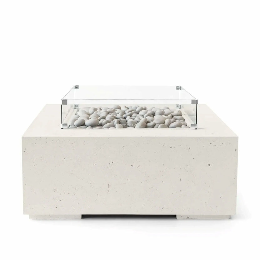 HPC Fire Hearth Products Controls Dekko GFRC Concrete Alea 40 x 40 Fire Pit in Limestone finish featuring ivory fire stones within a recessed burner area protected by a clear tempered glass wind guard. The light cream-colored GFRC concrete body showcases subtle texture and clean architectural lines, creating a sophisticated modern outdoor fire pit for patios, decks, and luxury outdoor living spaces.