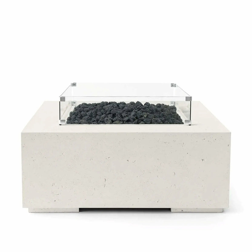 HPC Fire Hearth Products Controls Dekko GFRC Concrete Alea 40 x 40 Fire Pit in Limestone finish featuring black lava rock fire media inside a recessed burner area. The square GFRC concrete fire pit includes a clear tempered glass wind guard that surrounds the burner while maintaining an open, modern appearance. Front-facing studio product image highlighting the light limestone-colored concrete texture and contemporary outdoor fire feature design.