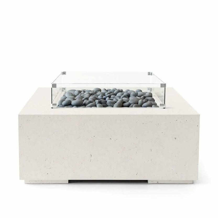 HPC Fire Hearth Products Controls Dekko GFRC Concrete Alea 40 x 40 Fire Pit finished in Limestone with smooth slate stone fire media displayed beneath a tempered glass wind guard. The clean-lined square fire pit features durable GFRC concrete construction and a light cream-toned finish that complements the gray decorative stones. Professional product image showcasing modern outdoor patio heating and architectural styling.