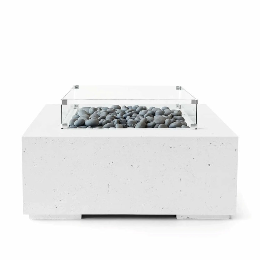 HPC Fire Hearth Products Controls Dekko GFRC Concrete Alea 40 x 40 Fire Pit in Natural finish featuring decorative slate stones inside the burner tray. A clear tempered glass wind guard surrounds the fire media, while the square GFRC concrete base provides a durable and modern foundation. Studio product photo showcasing the balanced combination of natural concrete tones and smooth gray stone media.