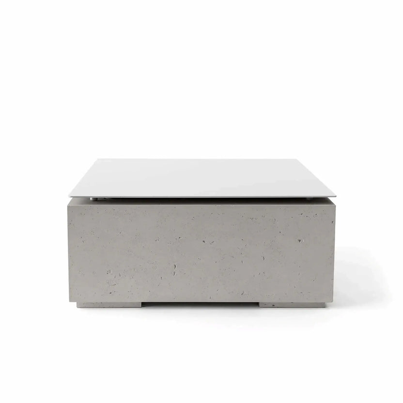HPC Fire Hearth Products Controls Dekko GFRC Concrete Alea Bravo 32 x 32 Fire Pit Sandstone Table Top Lid shown in a professional product image. The square protective cover rests on a sandstone-colored GFRC concrete fire pit base featuring warm neutral tones and subtle concrete texture. Designed for outdoor entertaining areas, the lid conceals the burner opening and transforms the fire pit into an elegant tabletop surface.