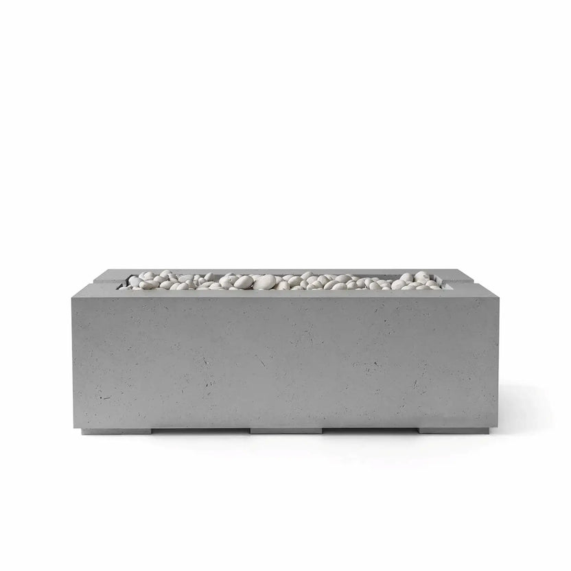 HPC Fire & Hearth Products Controls Dekko GFRC Concrete Avera 48 x 26 Fire Pit in Charcoal finish featuring decorative Ivory Stone media. The dark gray concrete body highlights the clean rectangular silhouette and linear burner opening filled with smooth white stones. Presented on a white background, this contemporary Avera fire pit offers a bold modern aesthetic for luxury outdoor living environments and backyard entertaining areas.