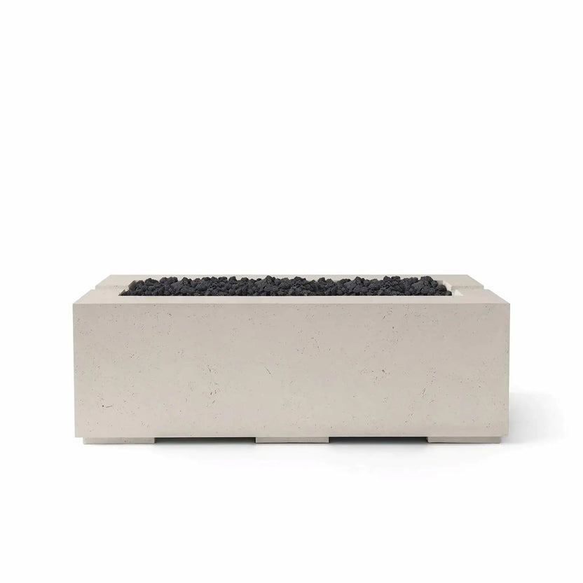 HPC Fire & Hearth Products Controls Dekko GFRC Concrete Avera 48 x 26 Fire Pit in Clay finish with black Lava Rock media. The rectangular GFRC concrete fire pit features a recessed linear burner opening filled with textured volcanic rock, creating strong visual contrast against the light clay-colored body. Shown on a clean white background, this Avera fire pit offers modern style and durable performance for outdoor entertaining areas.