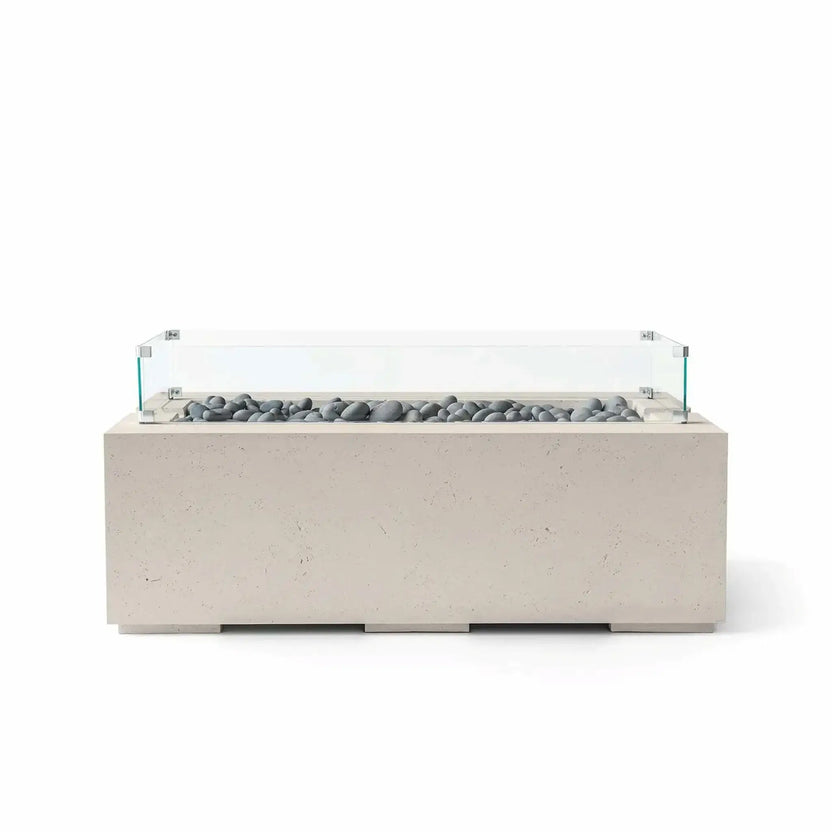 HPC Fire & Hearth Products Dekko GFRC Concrete Avera 48 x 26 Fire Pit Clay Slate Stone Tempered Glass Wind Guard featuring smooth gray slate stone media set within a rectangular burner tray. The warm clay-colored concrete body is complemented by a clear glass wind guard that adds protection and visibility while preserving the fire pit’s clean, modern outdoor design aesthetic.