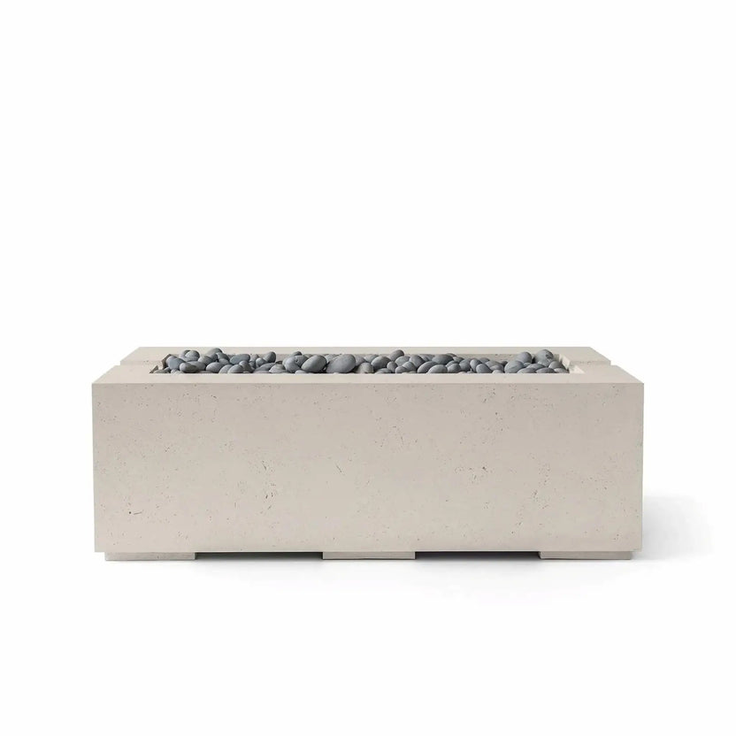 HPC Fire & Hearth Products Controls Dekko GFRC Concrete Avera 48 x 26 Fire Pit in Clay finish with Slate Stone media. The modern rectangular fire pit combines a warm-toned GFRC concrete exterior with smooth gray decorative stones arranged within the linear burner tray. Its clean geometric profile and premium materials make the Avera fire pit an elegant addition to patios, poolside lounges, and contemporary outdoor living environments.