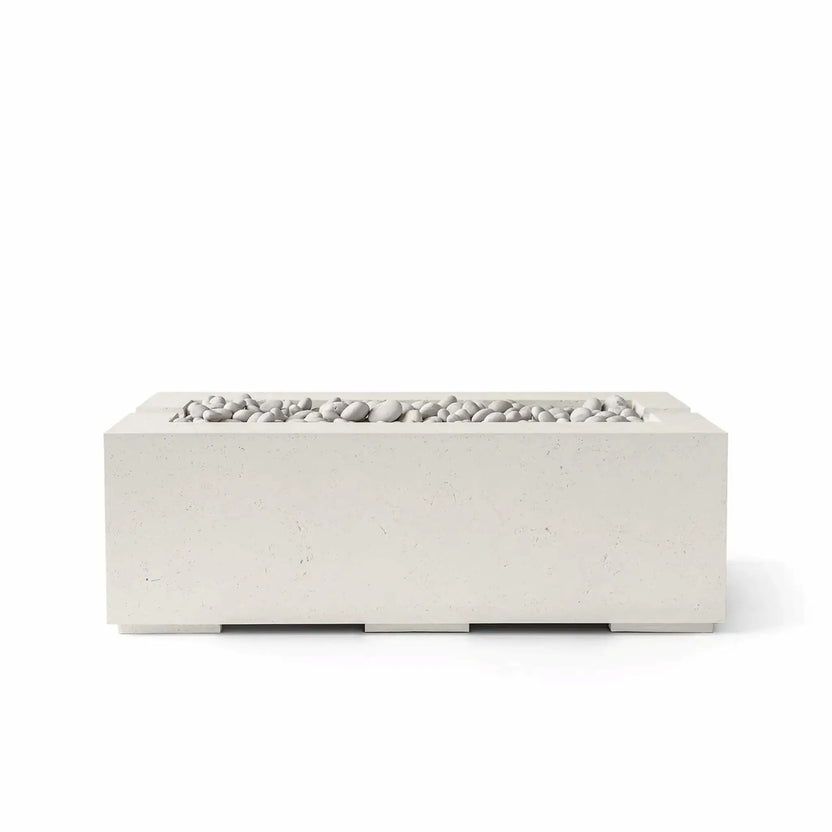 HPC Fire & Hearth Products Controls Dekko GFRC Concrete Avera 48 x 26 Fire Pit in Limestone finish featuring Ivory Stone media. The rectangular GFRC concrete fire pit showcases a soft cream-colored exterior paired with smooth white decorative stones arranged within the recessed linear burner tray. Displayed on a white background, the Avera fire pit offers a clean, contemporary aesthetic suited for patios, poolside lounges, and luxury outdoor living spaces.