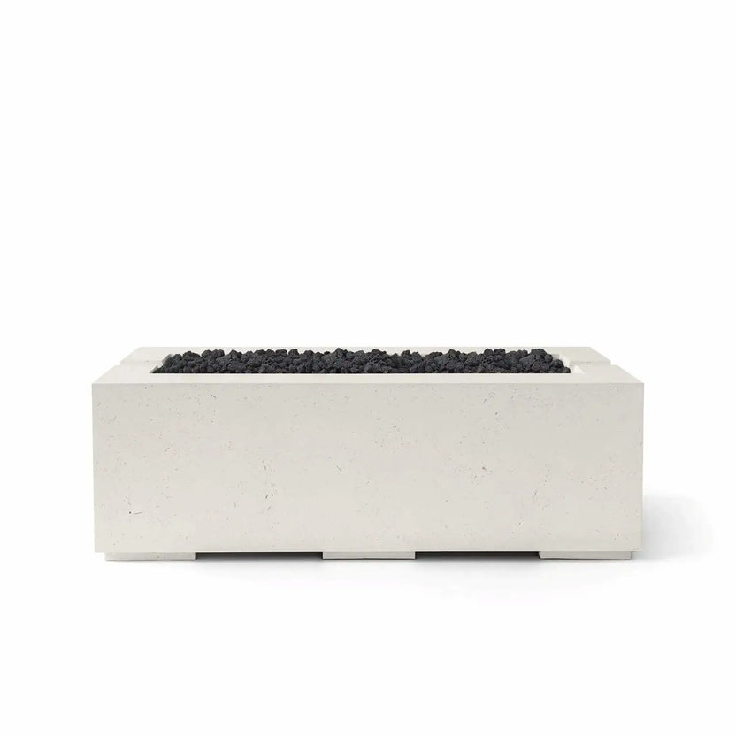 HPC Fire & Hearth Products Controls Dekko GFRC Concrete Avera 48 x 26 Fire Pit in Limestone finish with black Lava Rock media. The warm-toned GFRC concrete body contrasts beautifully with the rugged volcanic rock filling the linear burner opening. Shown in a studio product image on a white background, this modern Avera fire pit combines durable construction, contemporary styling, and premium outdoor performance for upscale residential and commercial spaces.