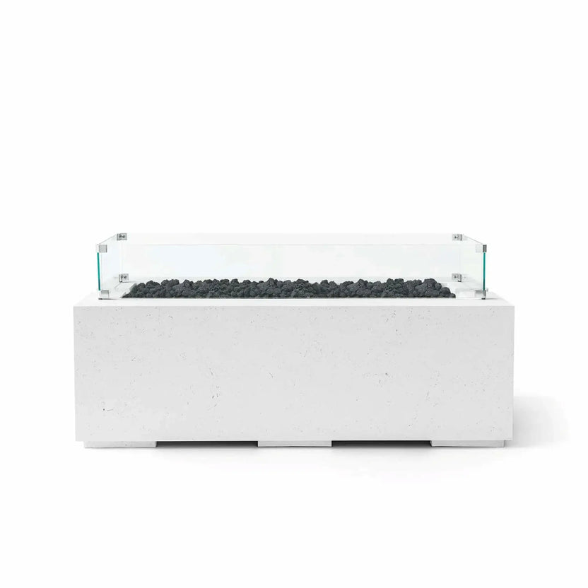 HPC Fire & Hearth Products Dekko GFRC Concrete Avera 48 x 26 Fire Pit Natural Lava Rock Tempered Glass Wind Guard shown with black lava rock media and a clear glass wind guard enclosure. The natural-finish GFRC concrete construction, elongated burner opening, and minimalist rectangular profile deliver a modern outdoor fire feature designed for patios, decks, rooftop lounges, and luxury backyard gathering areas.