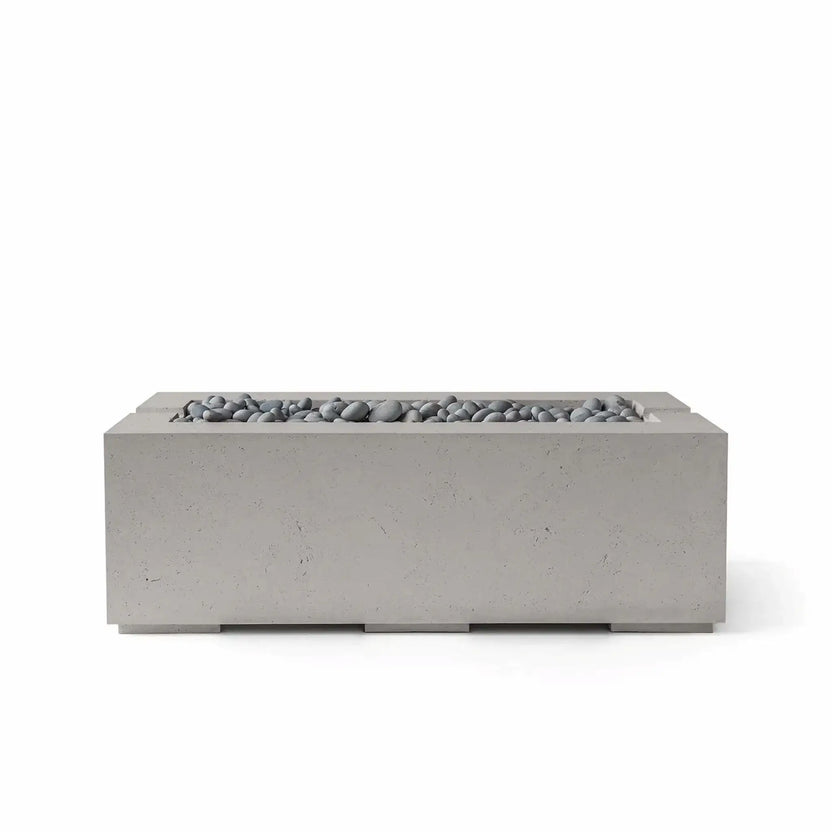 HPC Fire & Hearth Products Controls Dekko GFRC Concrete Avera 48 x 26 Fire Pit in Sandstone finish featuring Slate Stone media. The rectangular fire pit displays a textured sandstone-colored GFRC concrete body accented by smooth gray slate stones arranged along the elongated burner channel. Shown in a professional studio image on a white background, the Avera fire pit combines warm natural tones, contemporary design, and durable outdoor performance for patios, poolside seating areas, and upscale outdoor liv
