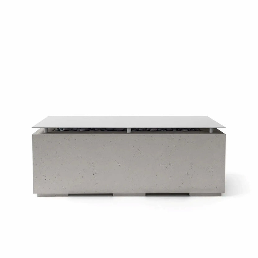 HPC Fire & Hearth Products Dekko GFRC Concrete Avera 48 x 26 Fire Pit Sandstone Table Top Lid shown in a light sandstone finish. The rectangular fire pit table includes a smooth metal tabletop cover elevated above the burner compartment, creating a sophisticated outdoor furniture piece. The textured GFRC concrete body and neutral sandstone color complement contemporary patios, pool decks, and outdoor seating areas.