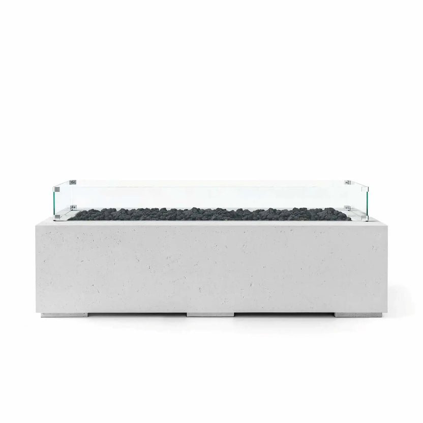 HPC Fire Hearth Products Controls Dekko GFRC Concrete Avera 60 x 26 Fire Pit in Ash finish with natural black lava rock media and a tempered glass wind guard surrounding the linear burner. The rectangular GFRC concrete fire pit features a modern architectural profile, textured gray surface, and low-profile design, creating a stylish focal point for contemporary outdoor entertaining areas and patio installations.