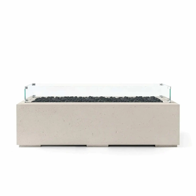 HPC Fire Hearth Products Controls Dekko GFRC Concrete Avera 60 x 26 Fire Pit featuring a Clay-colored concrete finish, natural black lava rock media, and a tempered glass wind guard. The elongated rectangular fire pit combines contemporary design, textured GFRC construction, and a linear burner enclosure to create an elegant focal point for outdoor entertaining and modern landscape environments.
