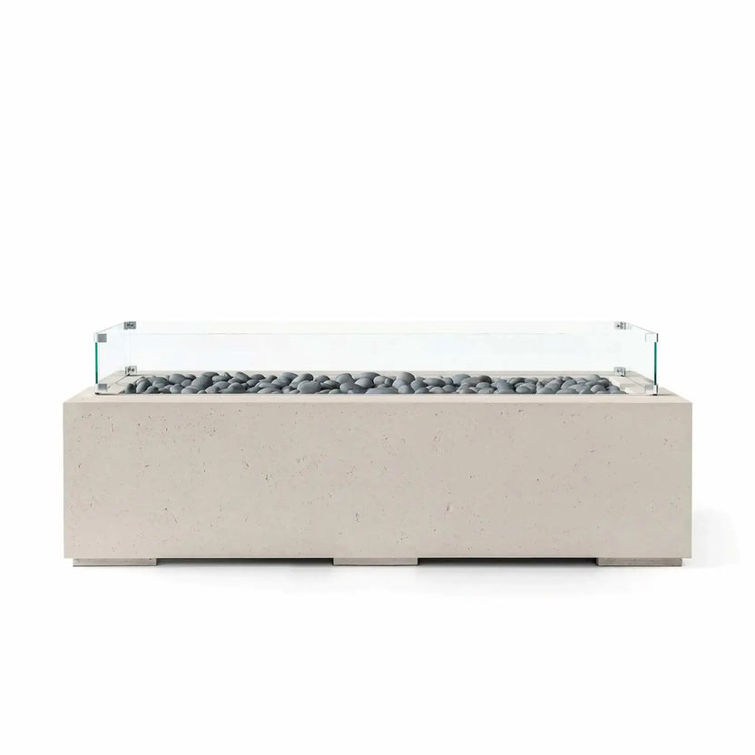 HPC Fire Hearth Products Controls Dekko GFRC Concrete Avera 60 x 26 Fire Pit in Clay finish with gray slate stone media and a clear tempered glass wind guard. The modern rectangular fire pit features a streamlined GFRC concrete body, elevated base supports, and a long linear burner area designed to enhance contemporary patios, outdoor lounges, and residential gathering spaces.