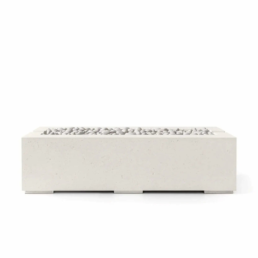 Studio product image of the HPC Fire Hearth Products Controls Dekko GFRC Concrete Avera 60 x 26 Fire Pit in Limestone finish with Ivory Stone media. The modern rectangular fire pit features durable glass fiber reinforced concrete construction, clean contemporary lines, and smooth white decorative stones arranged across the recessed burner opening for a refined outdoor aesthetic.